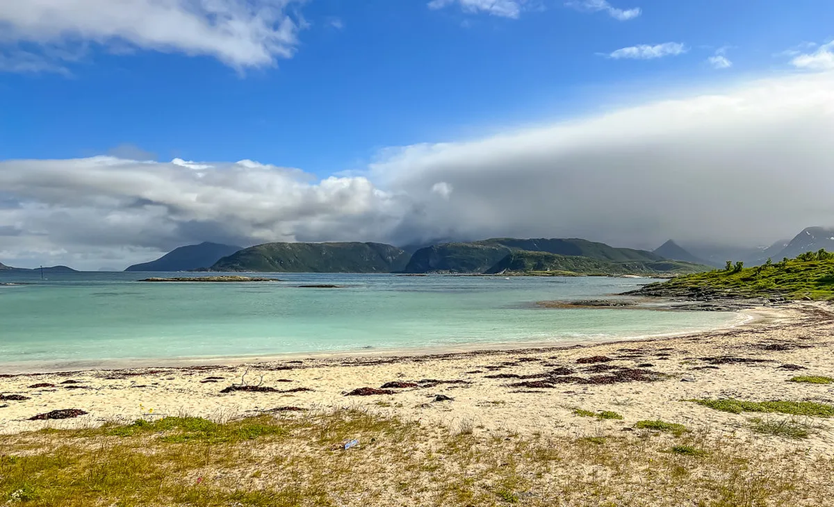 Sommarøy island white sand beach and turquoise waters near Tromsø with Arctic mountain backdrop