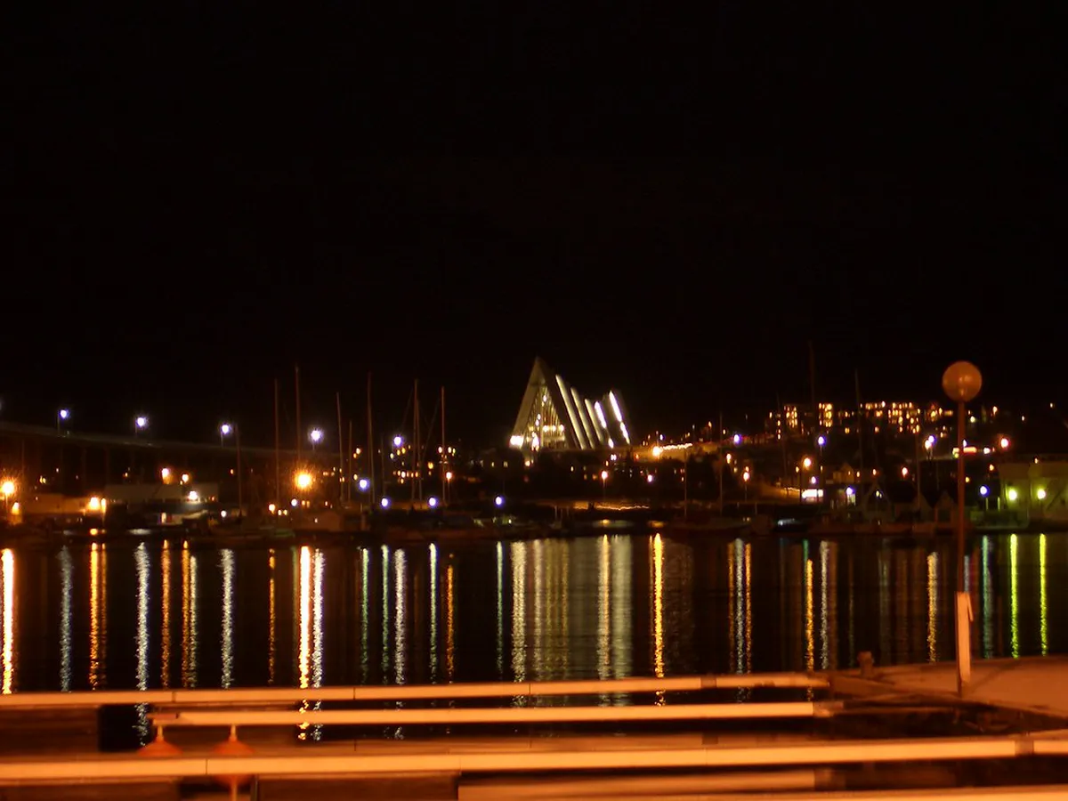 Arctic Cathedral in Tromsø, Norway at night with snow coverage and city lights