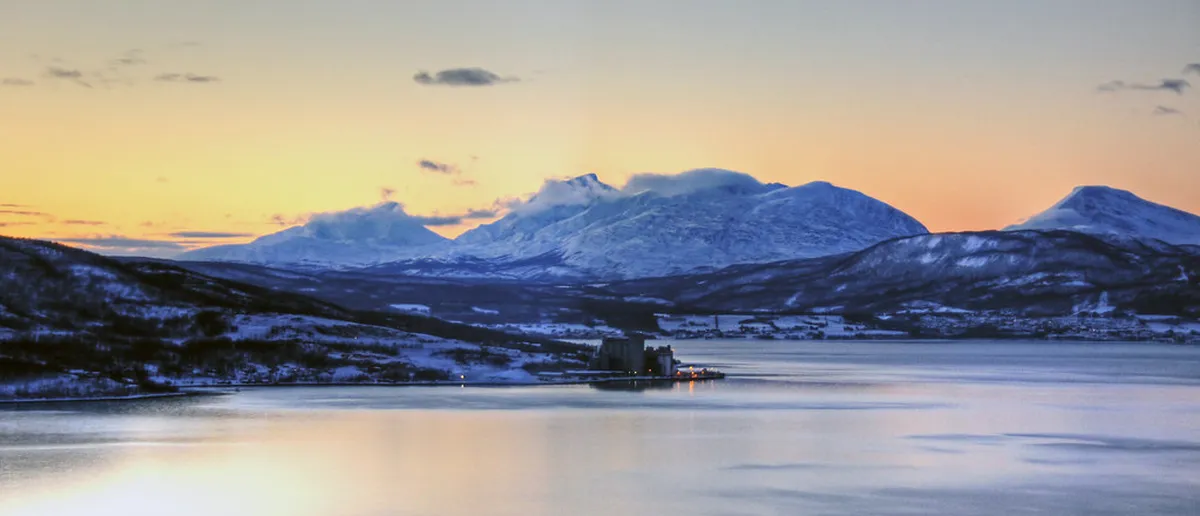 Snow-covered mountain landscape in Arctic Tromsø with dramatic frozen peaks and pristine wilderness