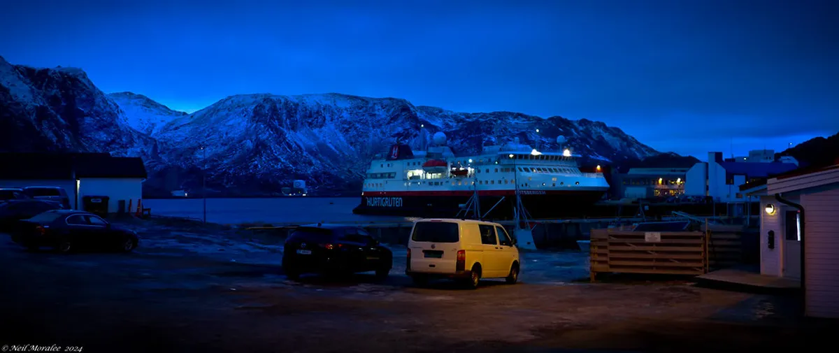Twilight blue hour light illuminates Tromsø's snow-covered landscape and fjord at midday during polar night, November to January