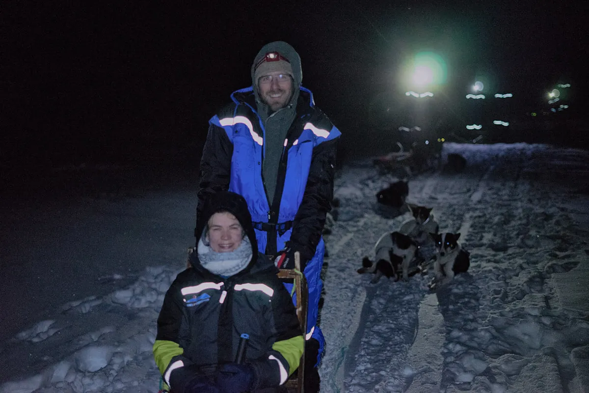Dog sled team racing across snowy Arctic landscape near Tromsø with guide and husky dogs in motion