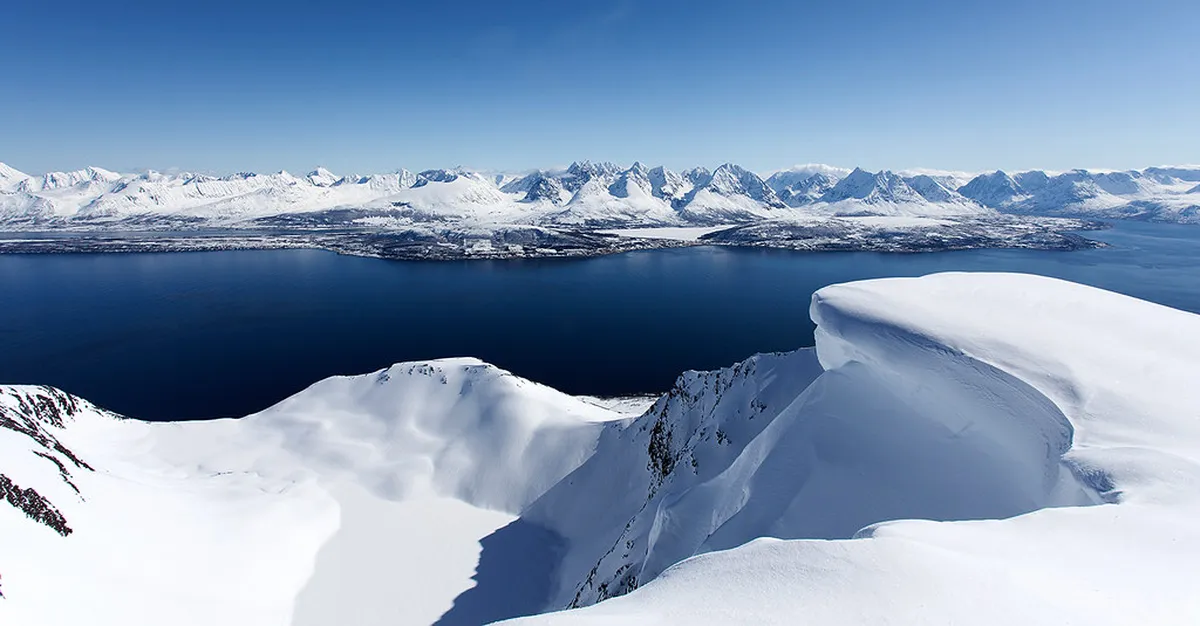Dramatic snow-covered peaks of Lyngen Alps in Tromsø region with frozen lakes below