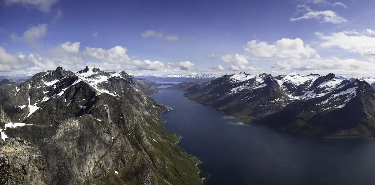 Mountain hiking trail in Tromsø, Norway with panoramic views of fjords, peaks, and Arctic landscape during the midnight sun season